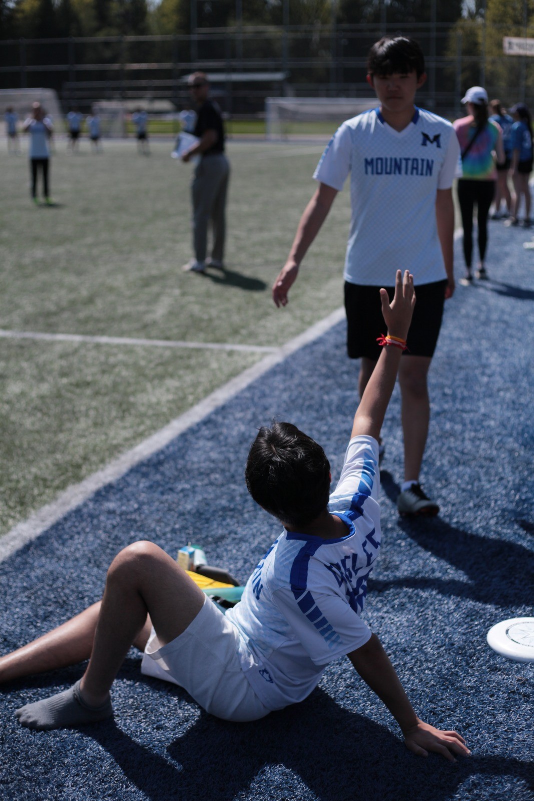 Sitting on the turf with an arm raised after a point